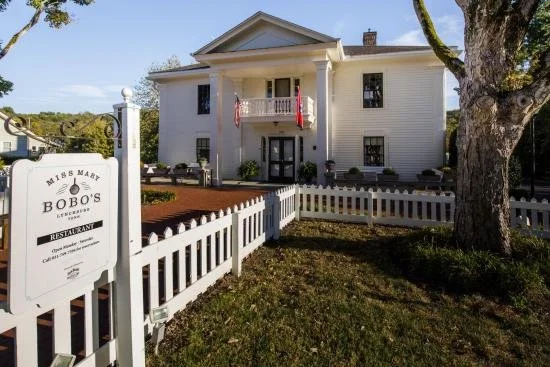 A white building with columns with a "Miss Mary Bobo's" sign in Nashville.