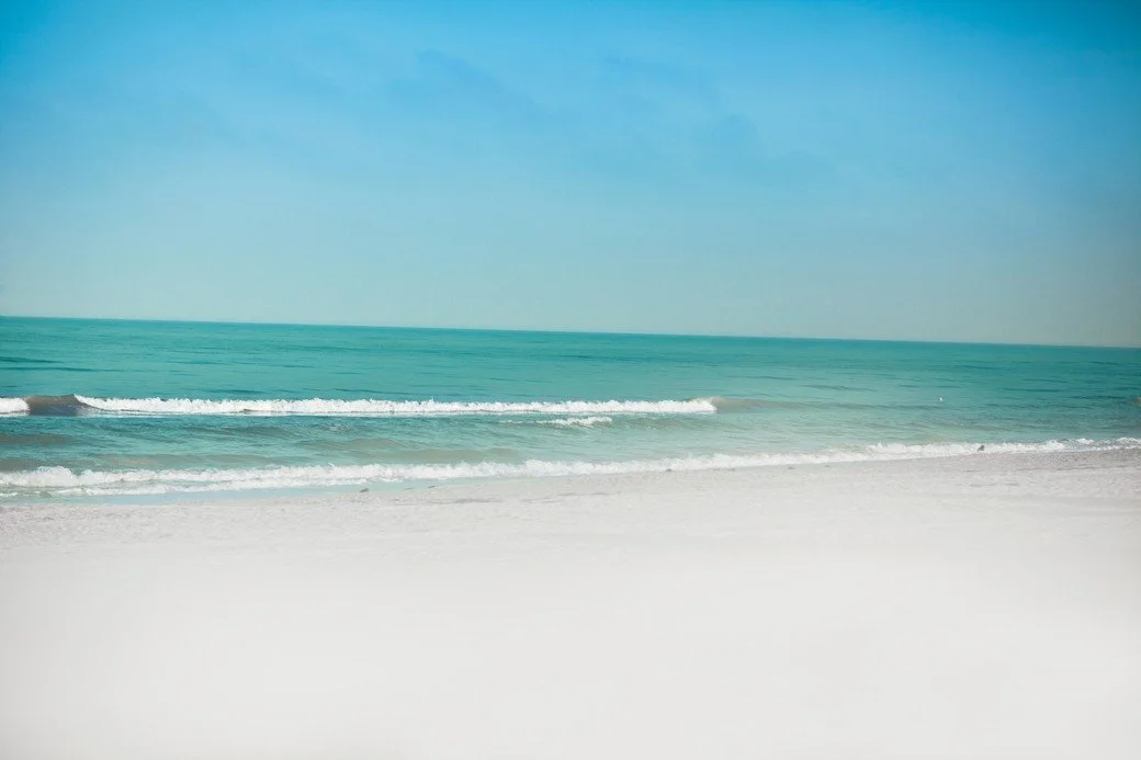 Crystal blue water laps against white sand beaches in St. Petersburg, Florida.