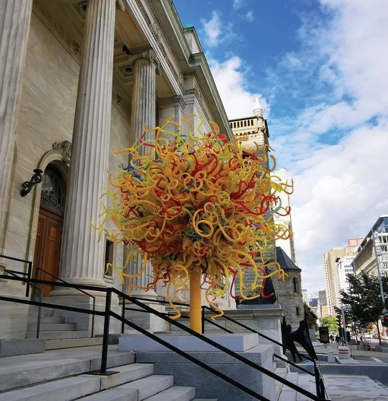 A swirly. colourful glass-blone sculpture out front of the Montreal Museum of Fine Arts.