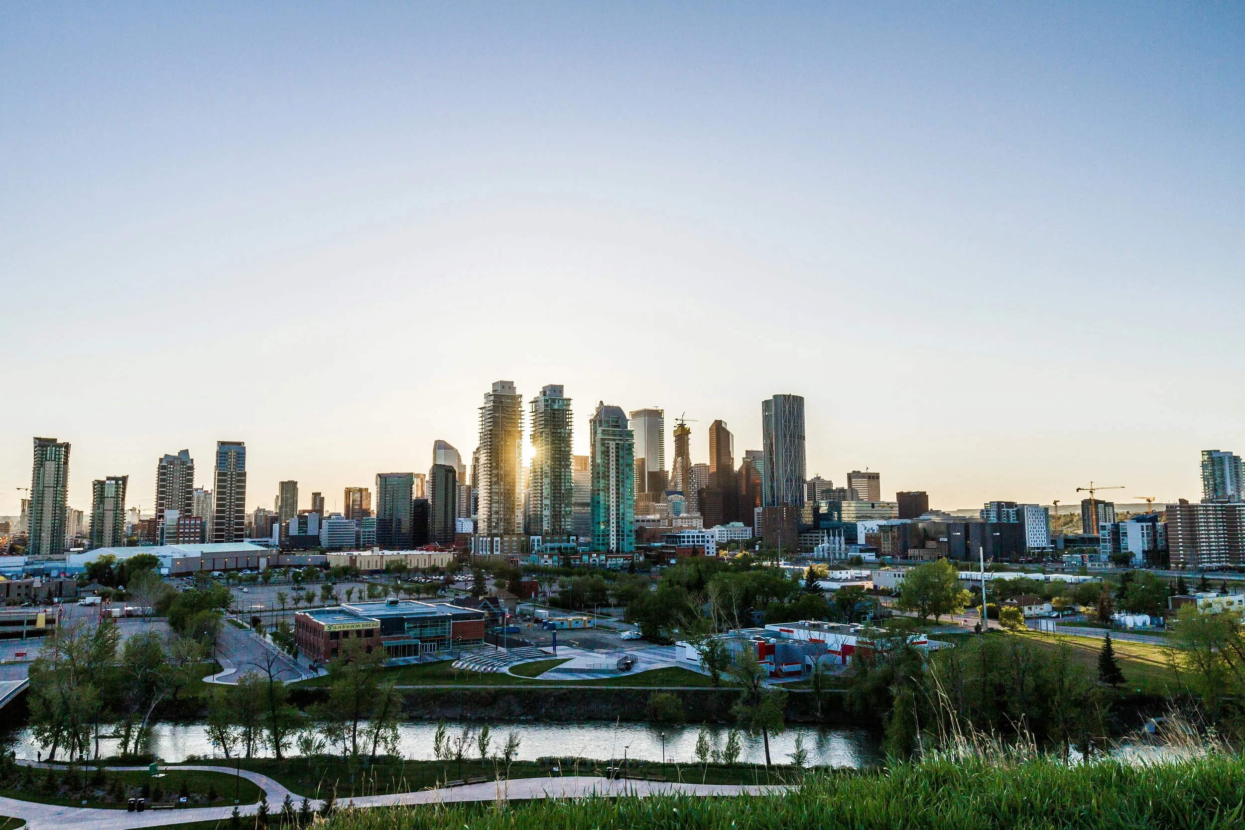 The Calgary skyline from above the Bow River during sunset.