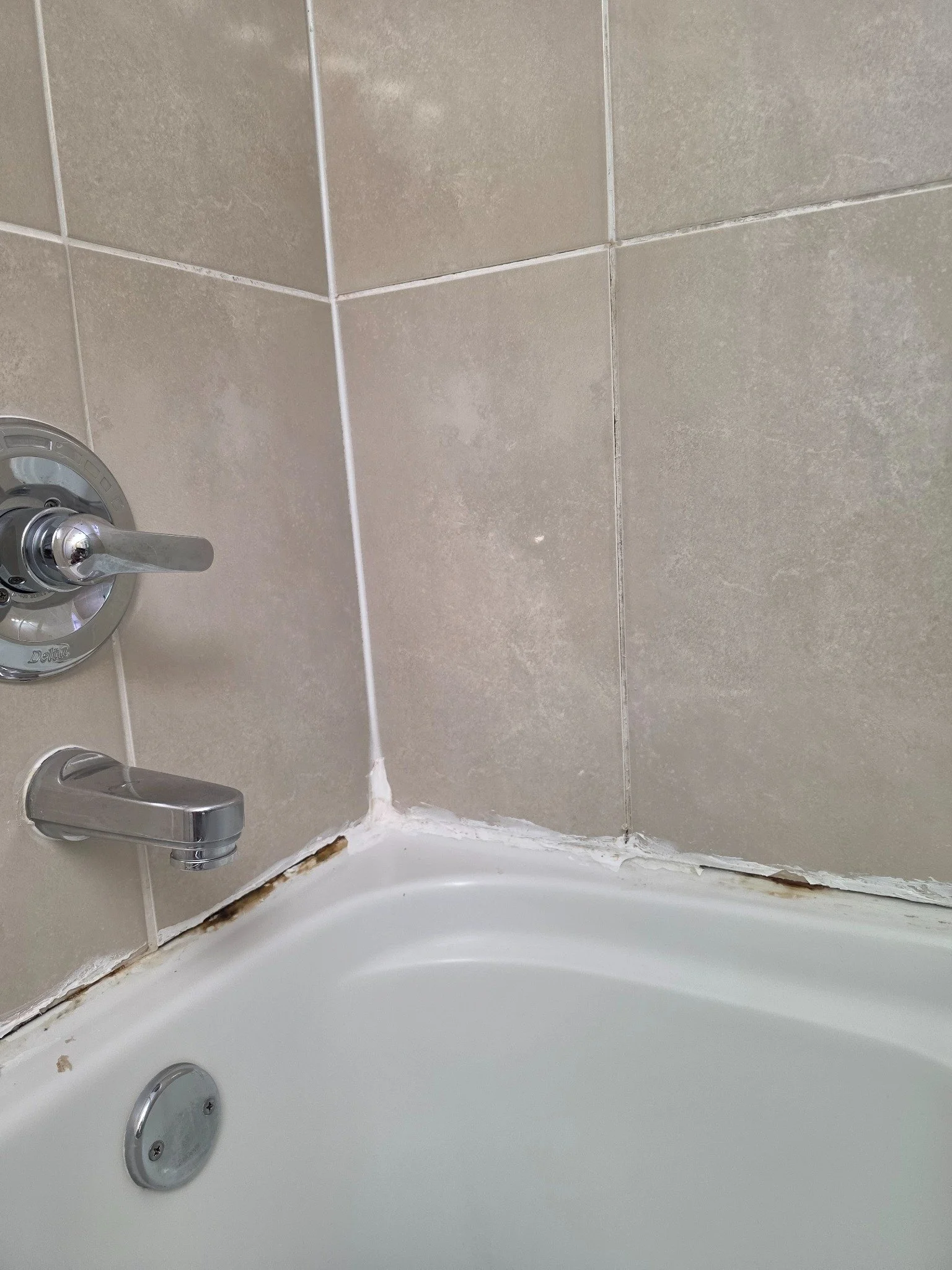 Before — Old and mould-stained bathtub sealant in Surrey, BC