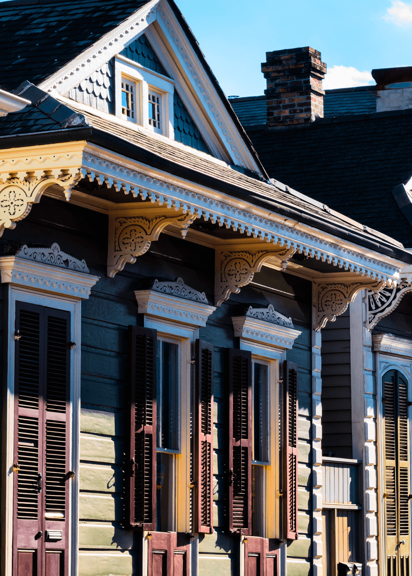 Colorful shotgun-style home in New Orleans with a long, narrow layout and front steps.