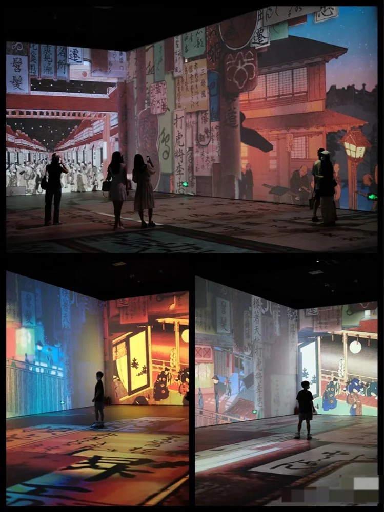Indoor immersive exhibit with large digital projections of traditional Japanese scenes and calligraphy; visitors observing and interacting with the displays.