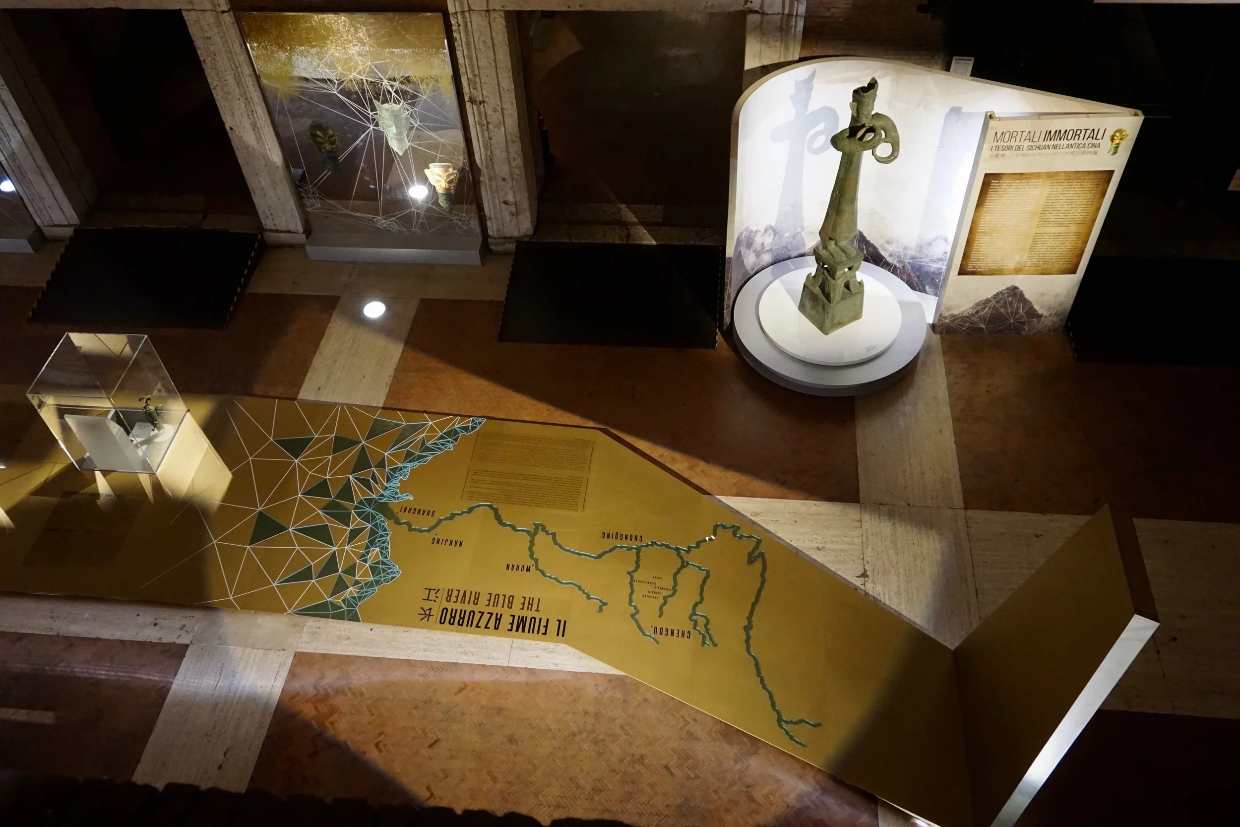 Exhibit in a museum featuring a large map of the Middle East and surrounding regions, a statue, and informational panels about the Ancient Near East.