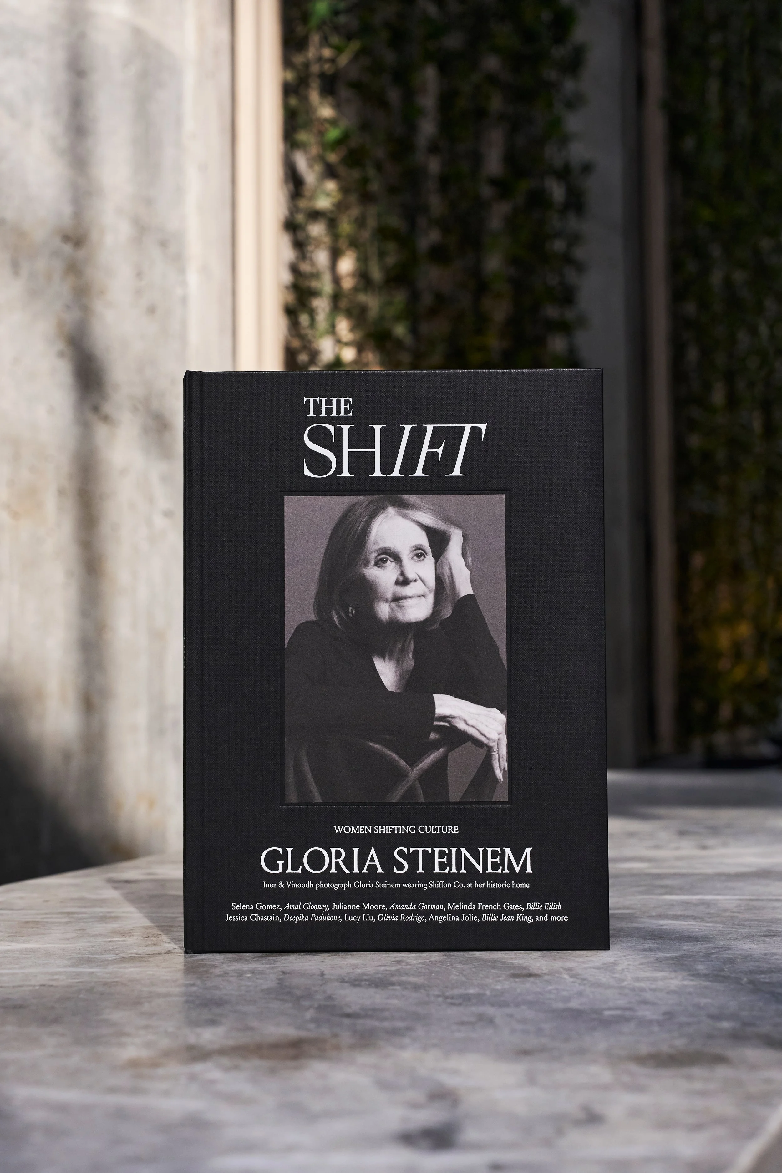 Book titled 'The Shift' by Gloria Steinem, featuring a black-and-white photo of Gloria Steinem on the cover, sitting with her hand on her head, in an outdoor setting with a concrete surface and a wall in the background.