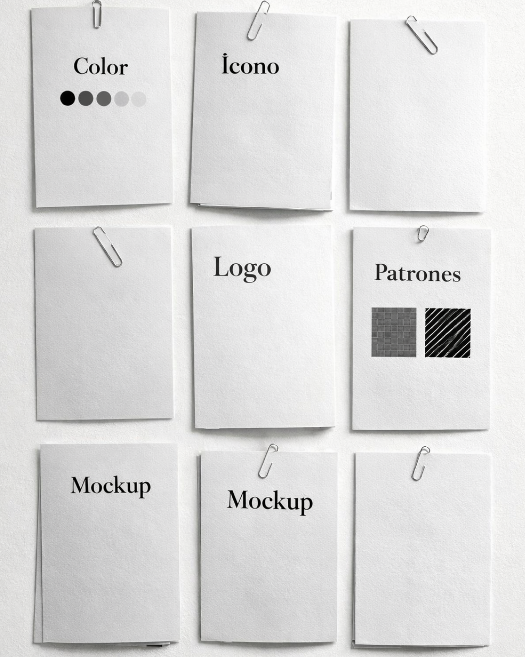 Papeletas blancas con textos y patrones en una pared, con clips que las sujetan.