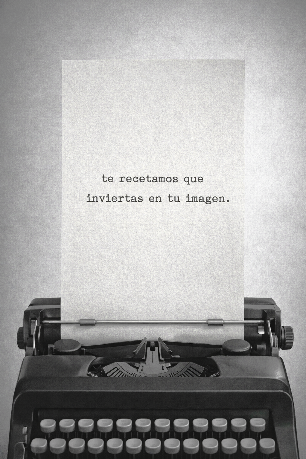 Máquina de escribir con una hoja que dice 'te recetamos que inviertas en tu imagen'.