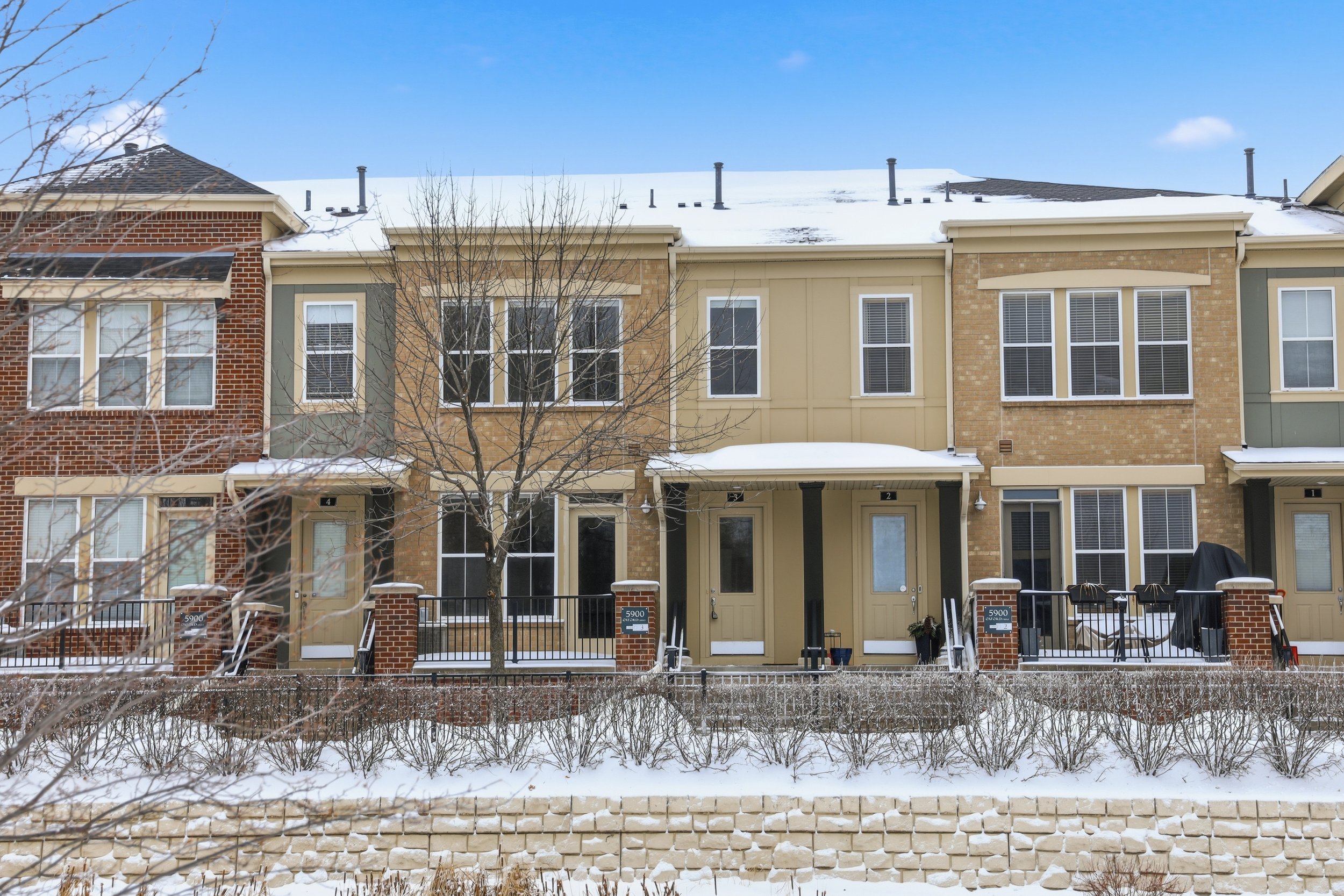 Front exterior of brick townhome in Saint Louis Park, Minnesota with patio in winter