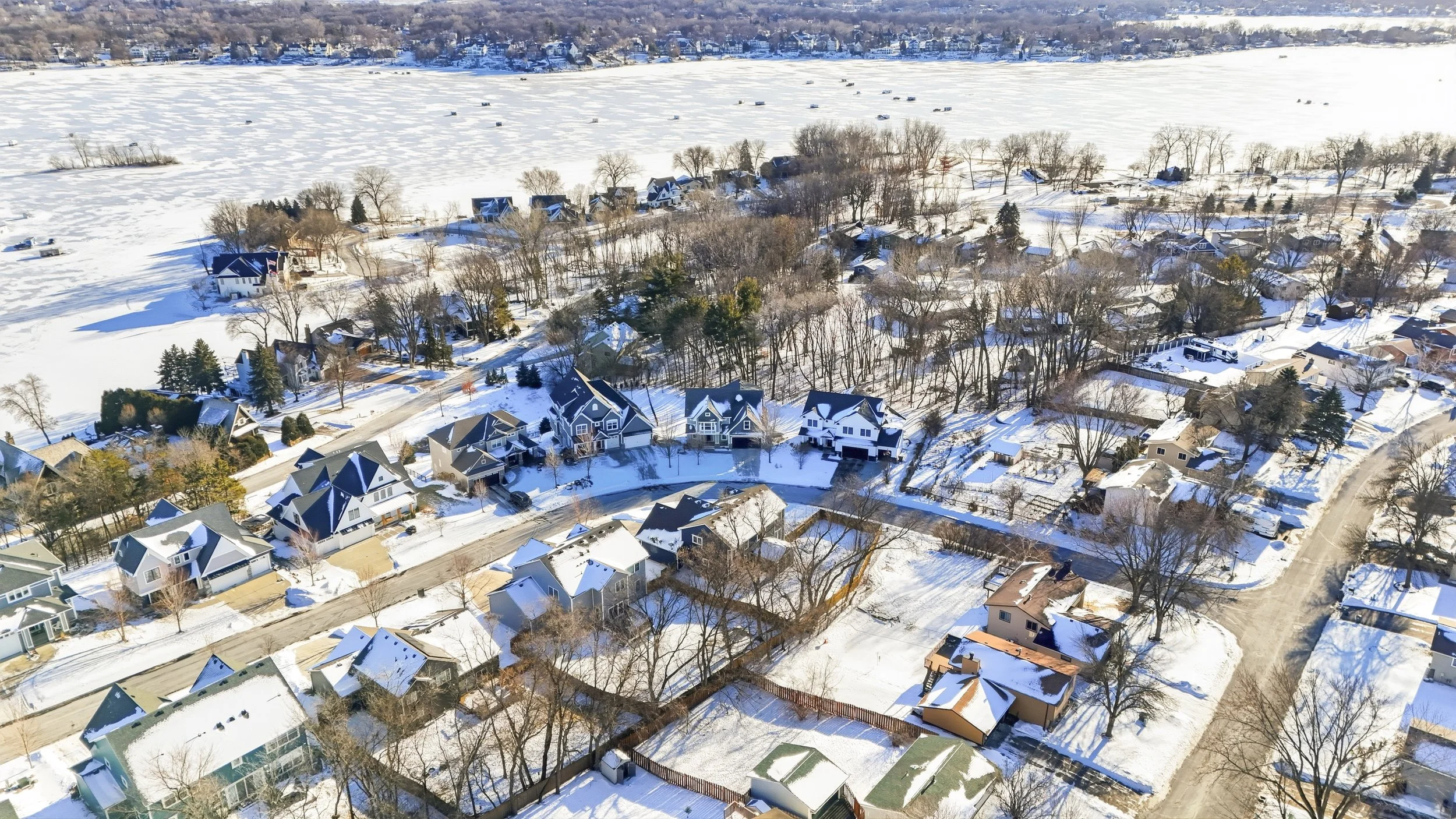 Drone photo of a snow-covered residential neighborhood near a frozen lake in the Prior Lake.