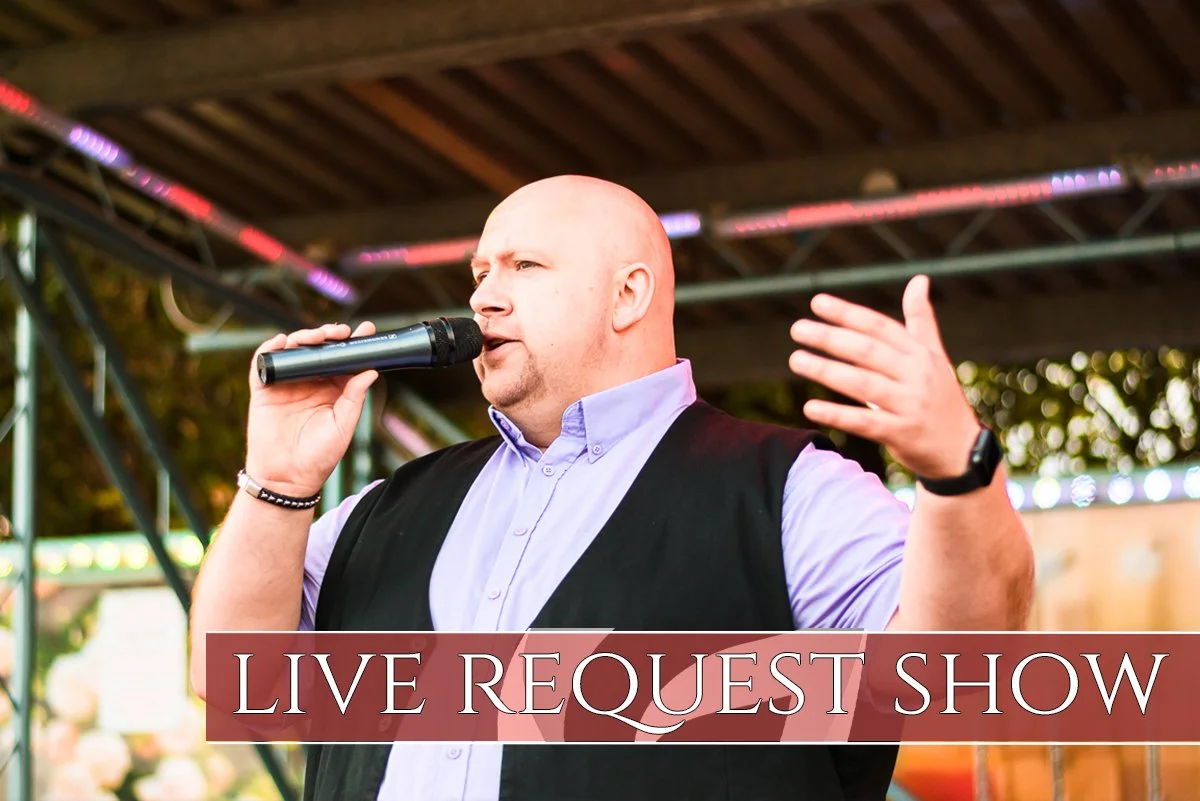 A man singing into a microphone on a stage with a banner that reads "LIVE REQUEST SHOW."