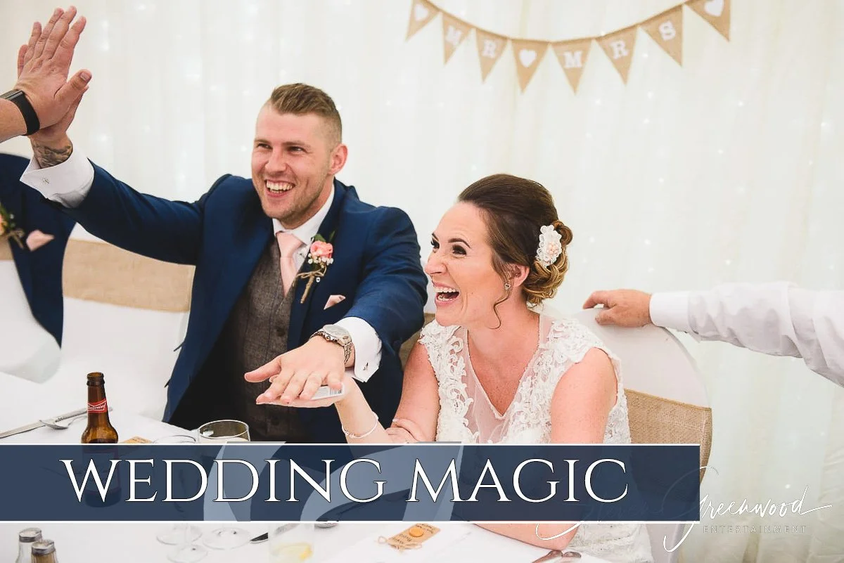 A bride and groom laughing and celebrating at their wedding reception, with wedding banners in the background. Magician Steven Greenwood