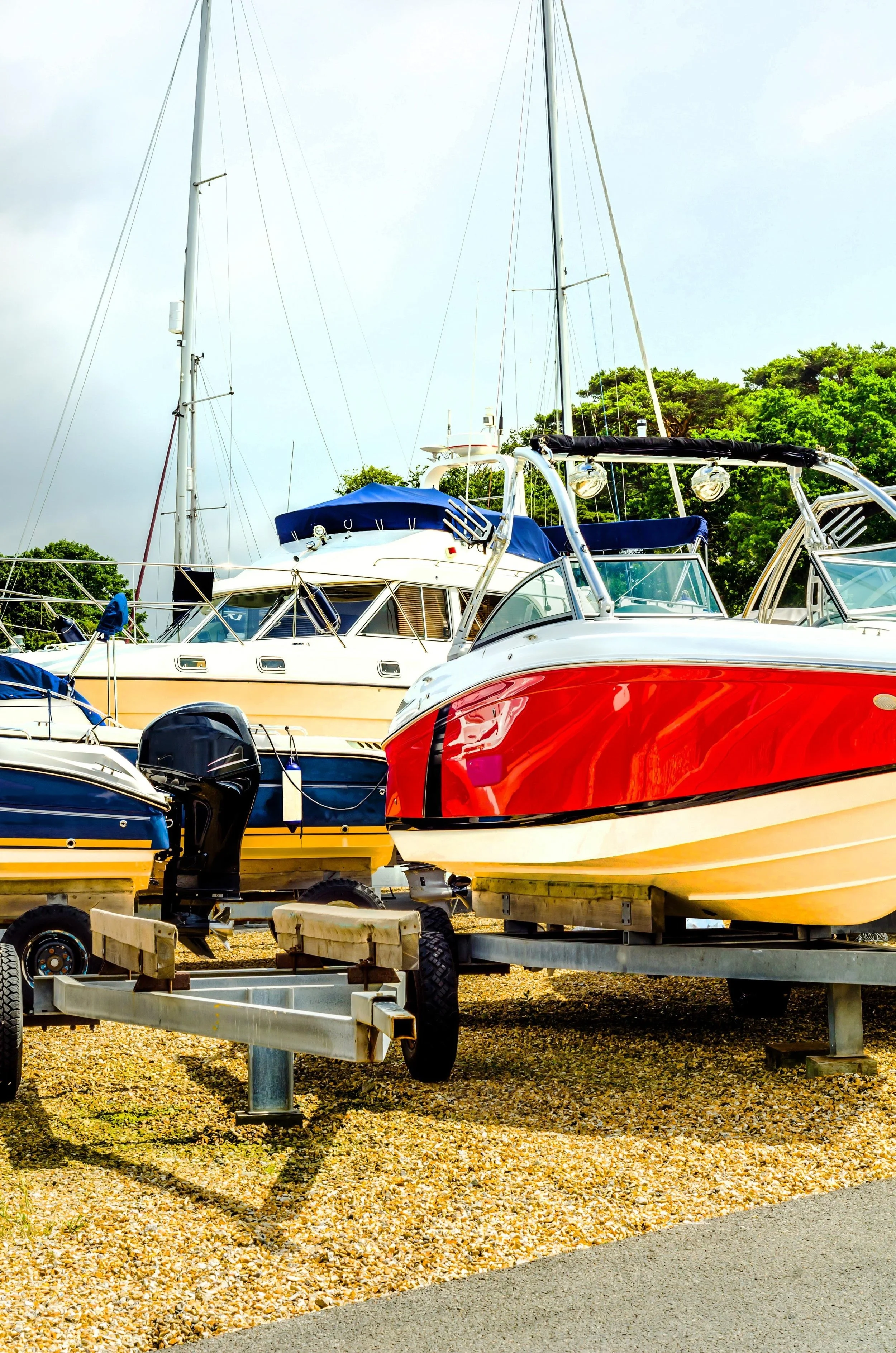 Scenic landscape of a large lake surrounded by rolling hills and mountains under a cloudy sky.