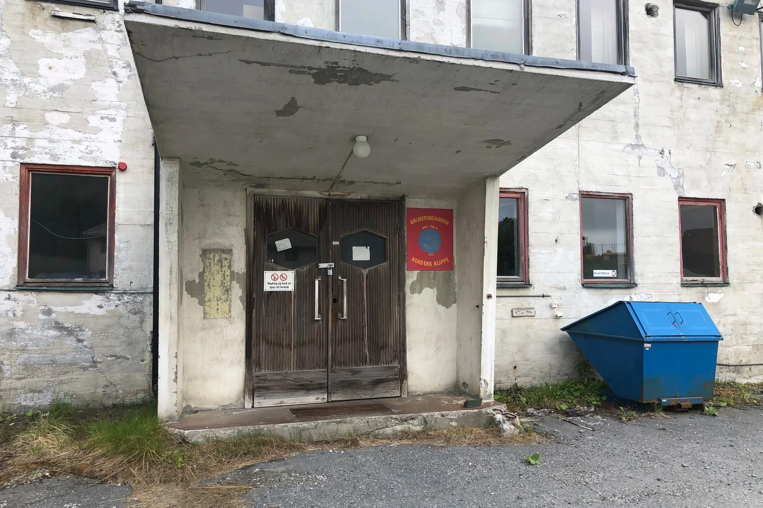 Dette bygget inneholdt lager. Her skimter vi Nordens Klippes plakat ved inngangsdøra.