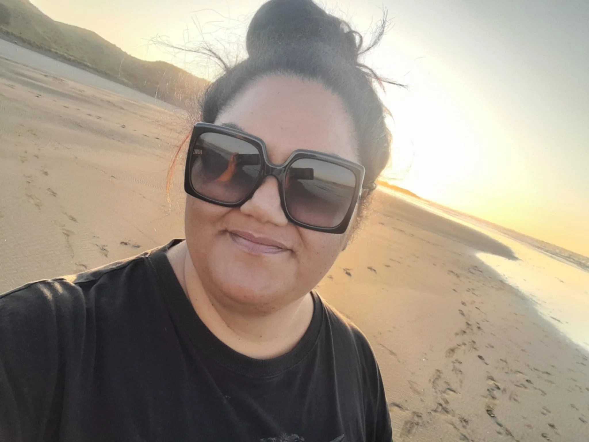 Marree Sylva - Founding partner of Ka ū ki Sticker Co. Selfie of Marree at Te Maika in the sunset.