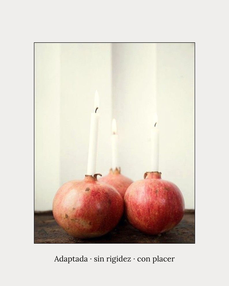 Granadas con velas encendidas en ellas sobre una superficie de madera, fondo blanco, imagen artística y decorativa.
