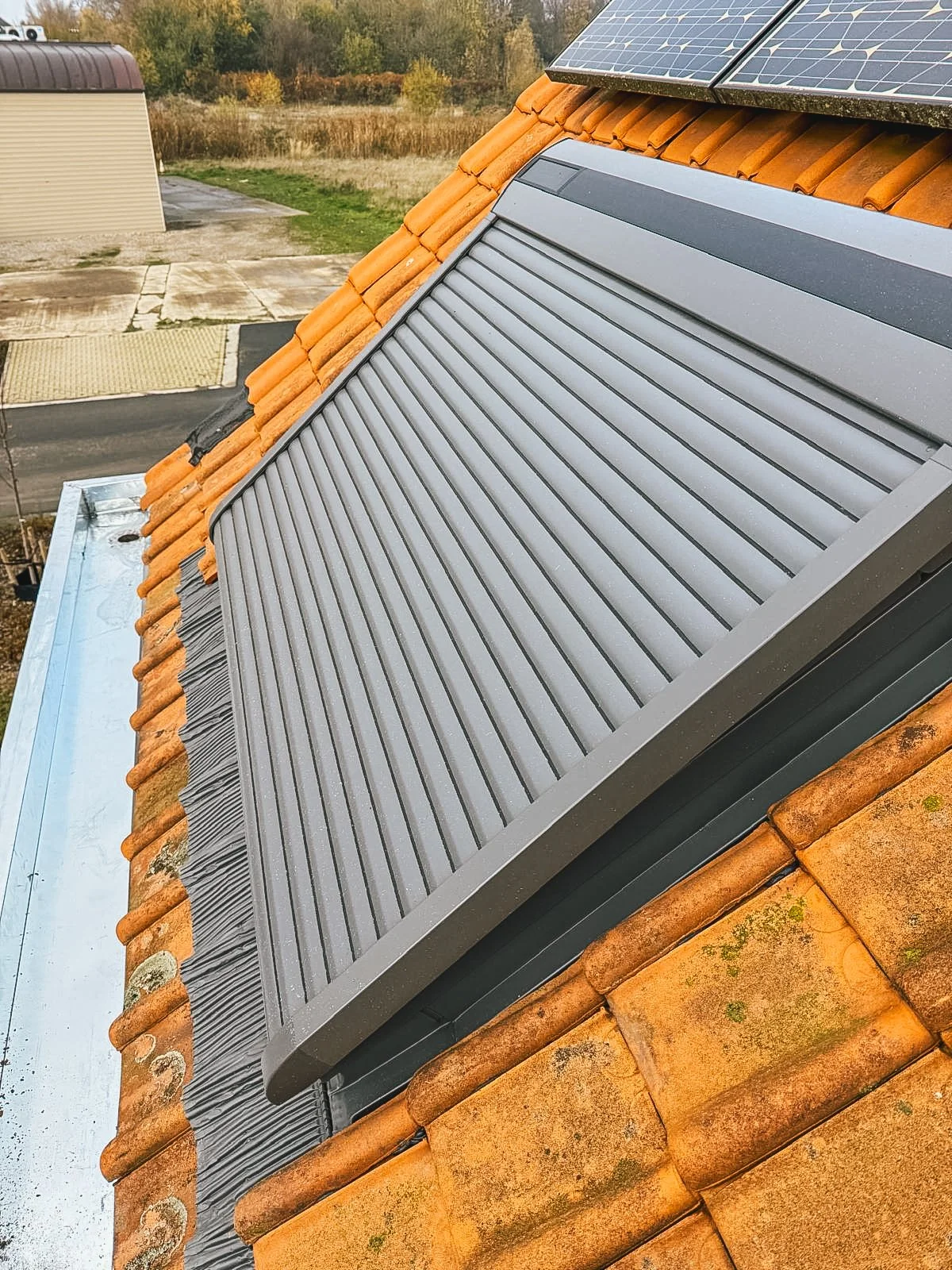 Daktegel met zonnepanelen en een ventilatieschuif.