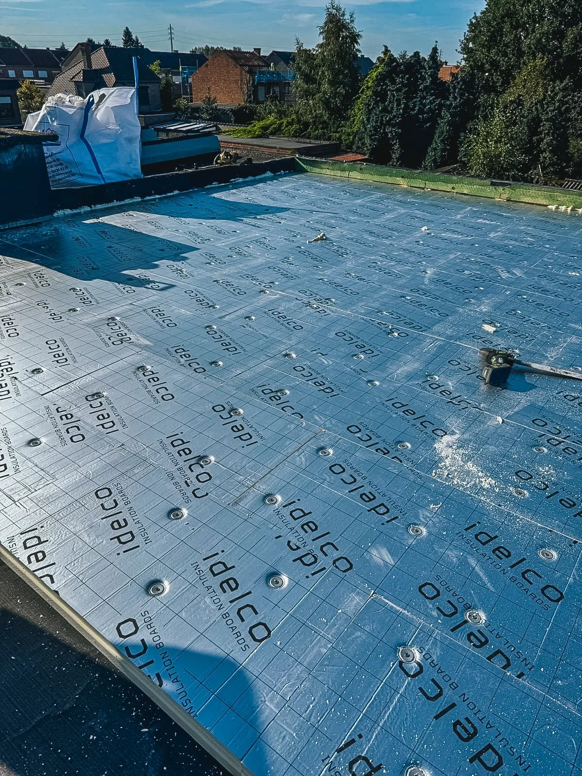 Renovatie op het dak met isolatieplaten en gereedschap.