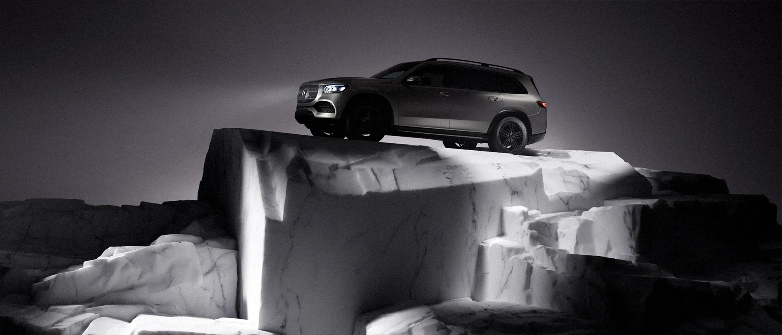 Ein schwarzer SUV fährt auf einem Eisberg bei Nacht.