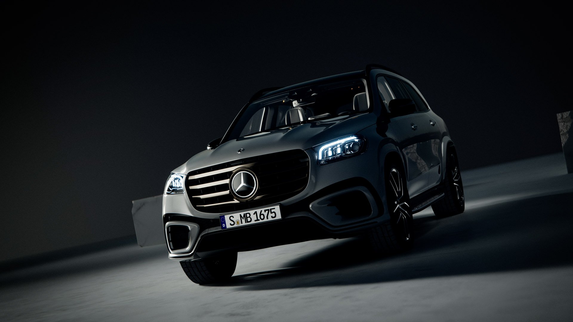 Ein schwarzer Mercedes-Benz Geländewagen bei Nacht, beleuchtet mit Scheinwerfern, vor dunklem Himmel und moderner Architektur im Hintergrund.