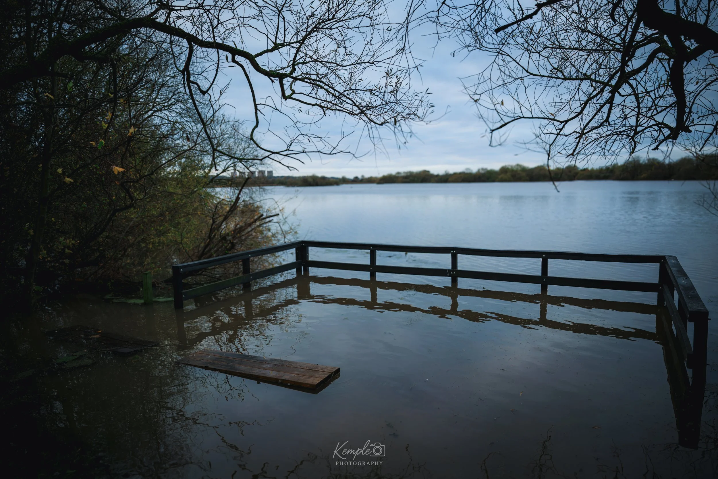 A quiet, atmospheric scene at Attenborough Nature Reserve, where rising water has submerged the viewing platform. Soft reflections ripple across the surface, creating a calm and slightly surreal moment in the landscape. A peaceful glimpse of nature r