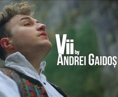 Close-up of a young man with curly hair looking up outdoors, with the text "Vii by Andrei Gaidos" on the right.