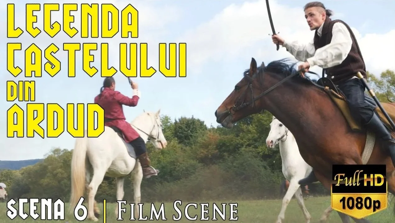 Screenshot from a film scene showing two men on horseback fighting with swords in a field with trees in the background. Large yellow text at the top reads 'Legenda Castellului din Ardud'. Additional text at the bottom says 'Scena 6 | Film Scene'. A black and gold logo in the bottom right corner reads 'Full HD 1080p'.
