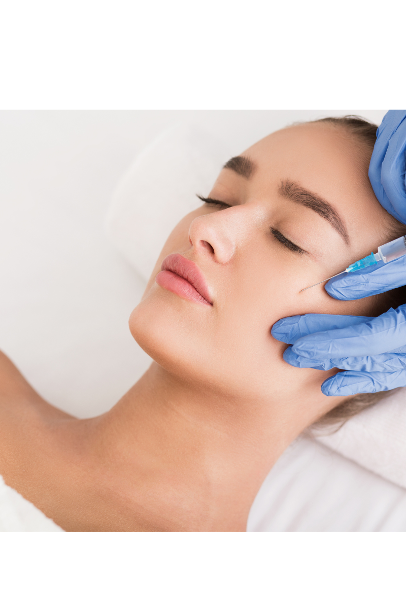 Frau erhält eine kosmetische Injektion im Gesicht, vom Arzt mit blauen Handschuhen.