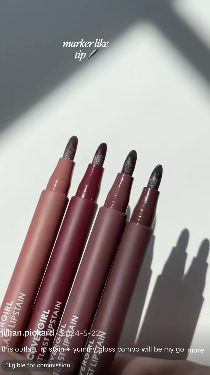 Four lipstick pencils in different shades of pink and red, with white powder on the tips, lying on a white surface with shadows falling on them. Text on image says 'marker like tip' with a pen icon.