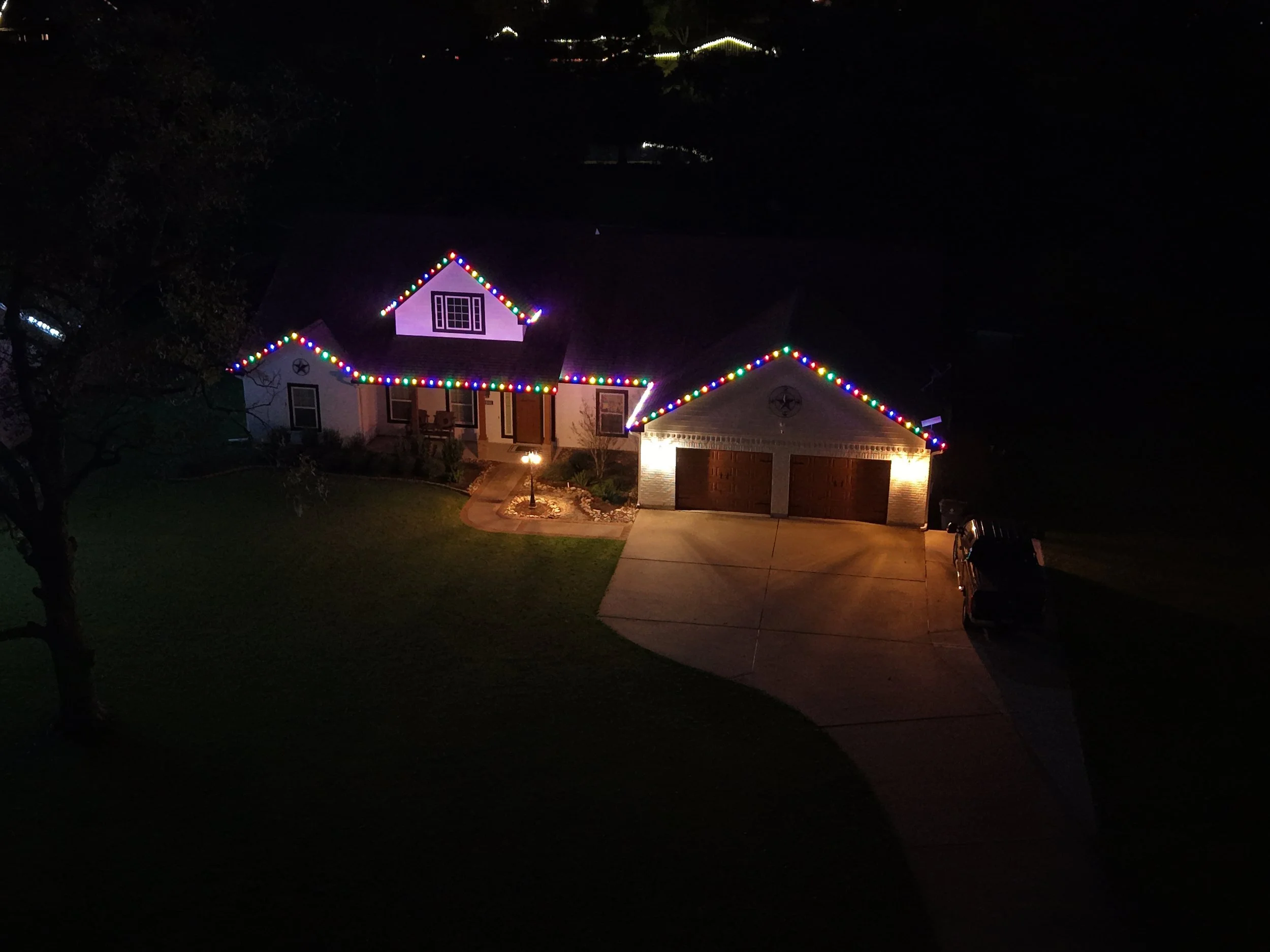 A house decorated with multicolored Christmas lights at night.