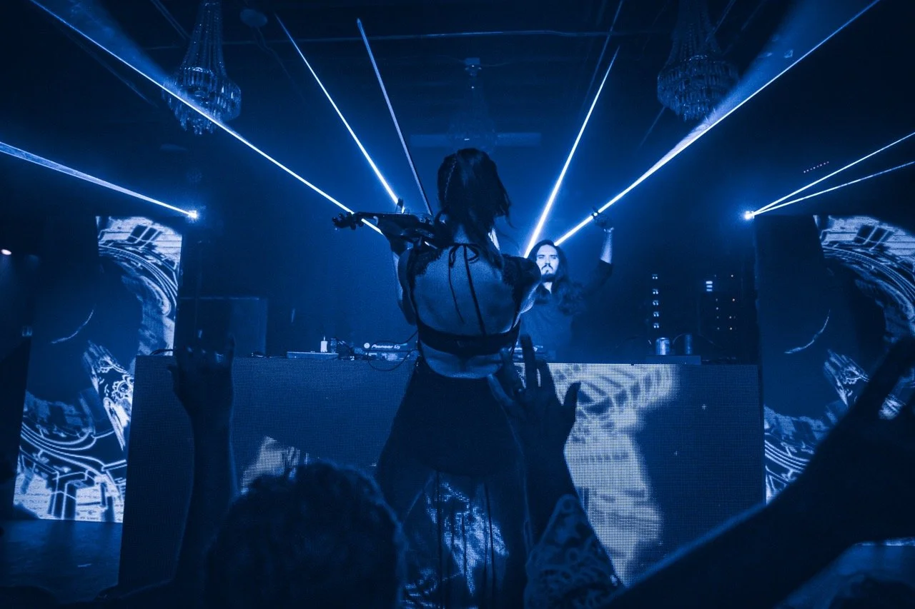Jessica Borth of Spectacle playing a violin on stage at Cervantes' Other Side, with laser lights, with DJ and audience members raising their hands.