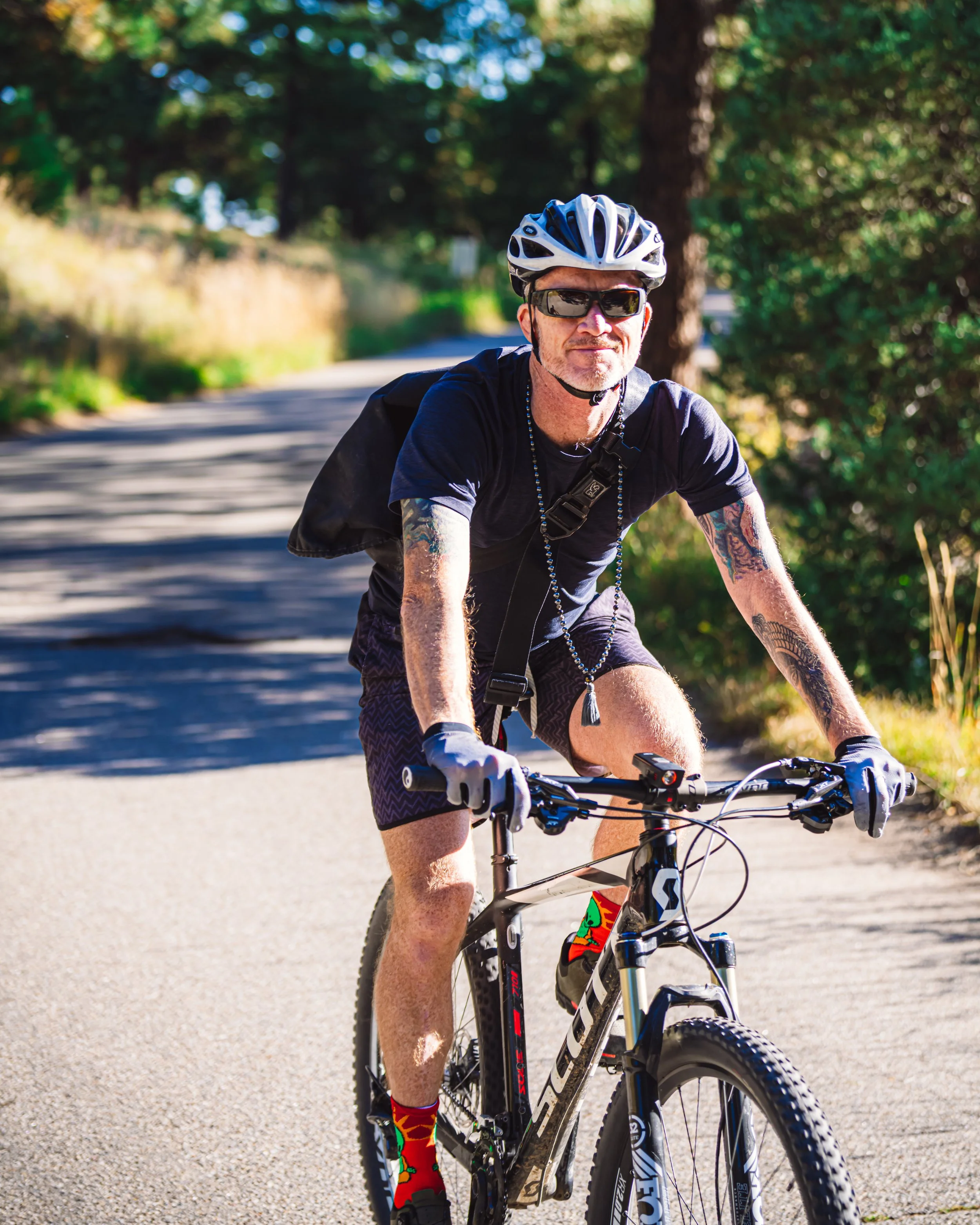 Rob Loud riding mountain bike on a shaded trail on Flagstaff Mountain in Boulder, CO. 