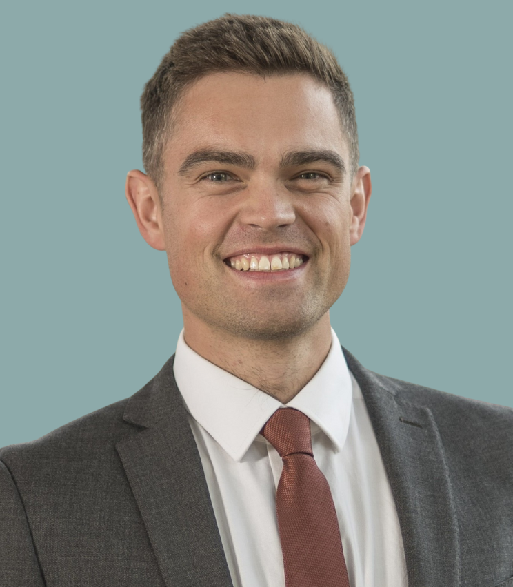 A photo of Laurie, smiling against a blue background.