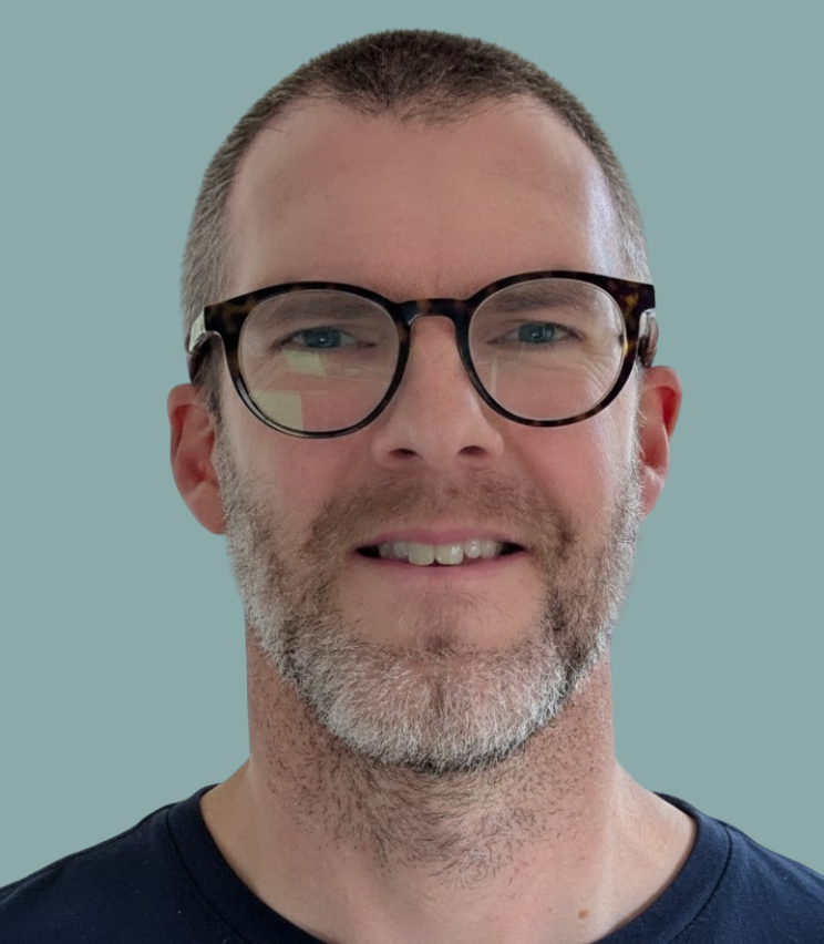 Tim wearing a dark t-shirt against a plain background.
