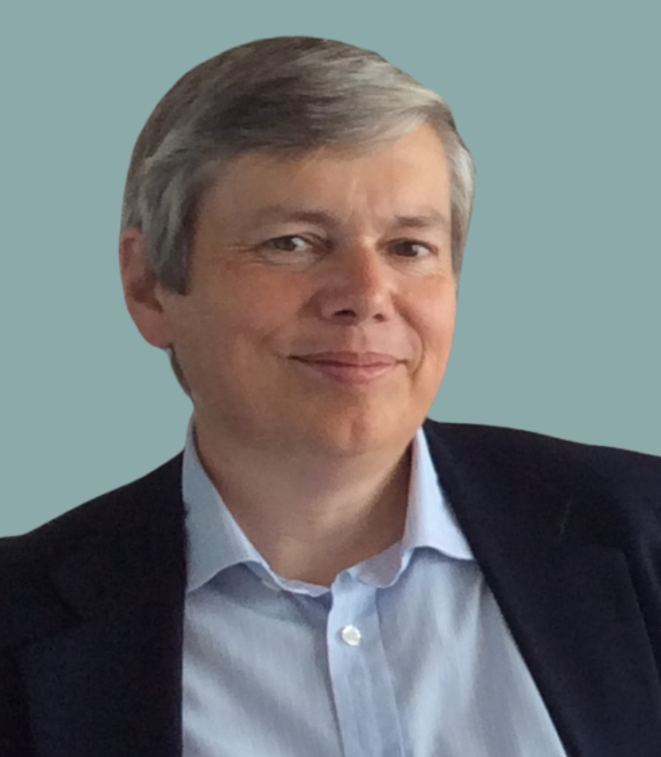 A photo of Keith, smiling at the camera against a plain gray background.