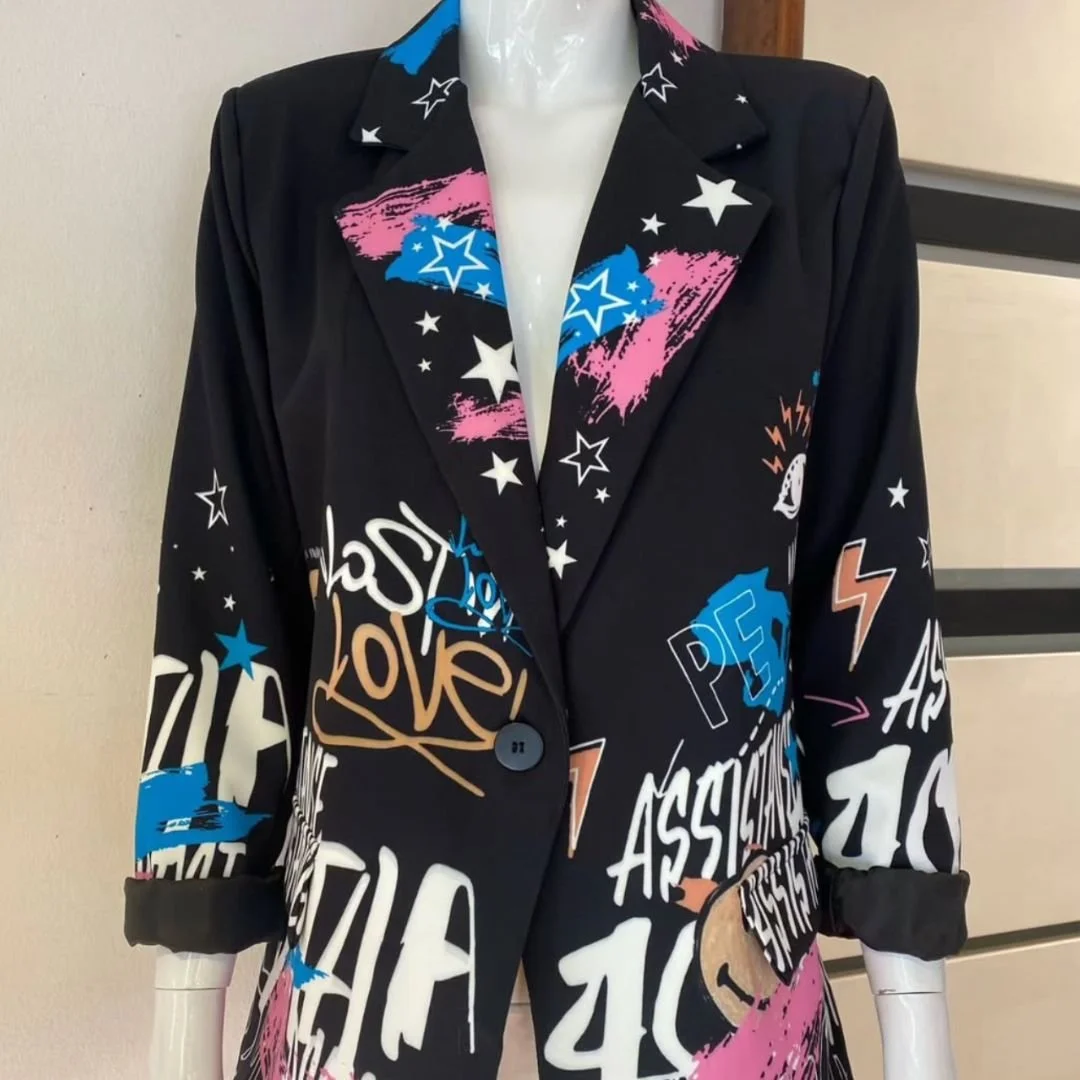 Black blazer with colorful graffiti-style text and star designs, some sleeve cuffs rolled up.