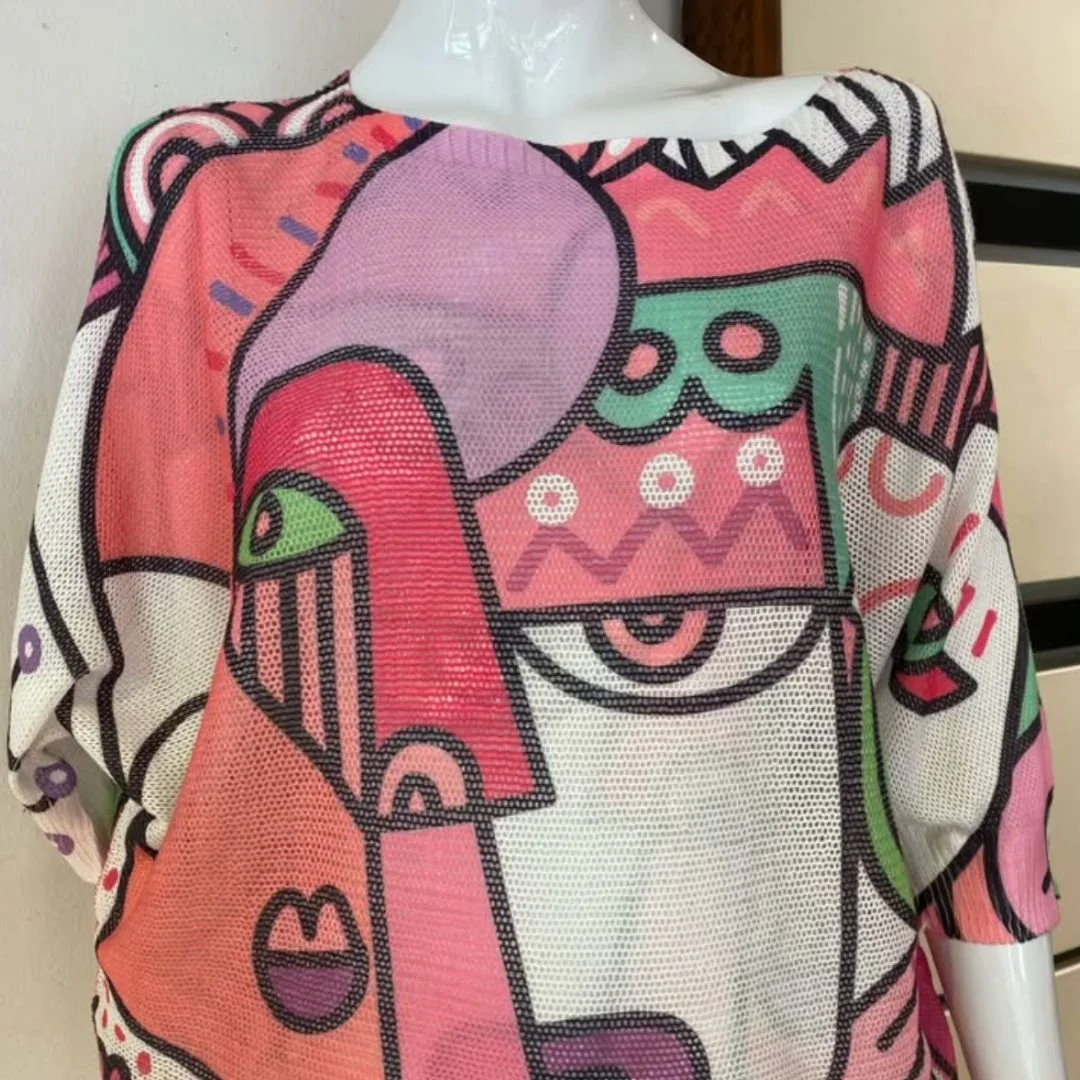 Colorful abstract design on a fabric top, featuring bold lines and shapes in pink, purple, green, black, and white.
