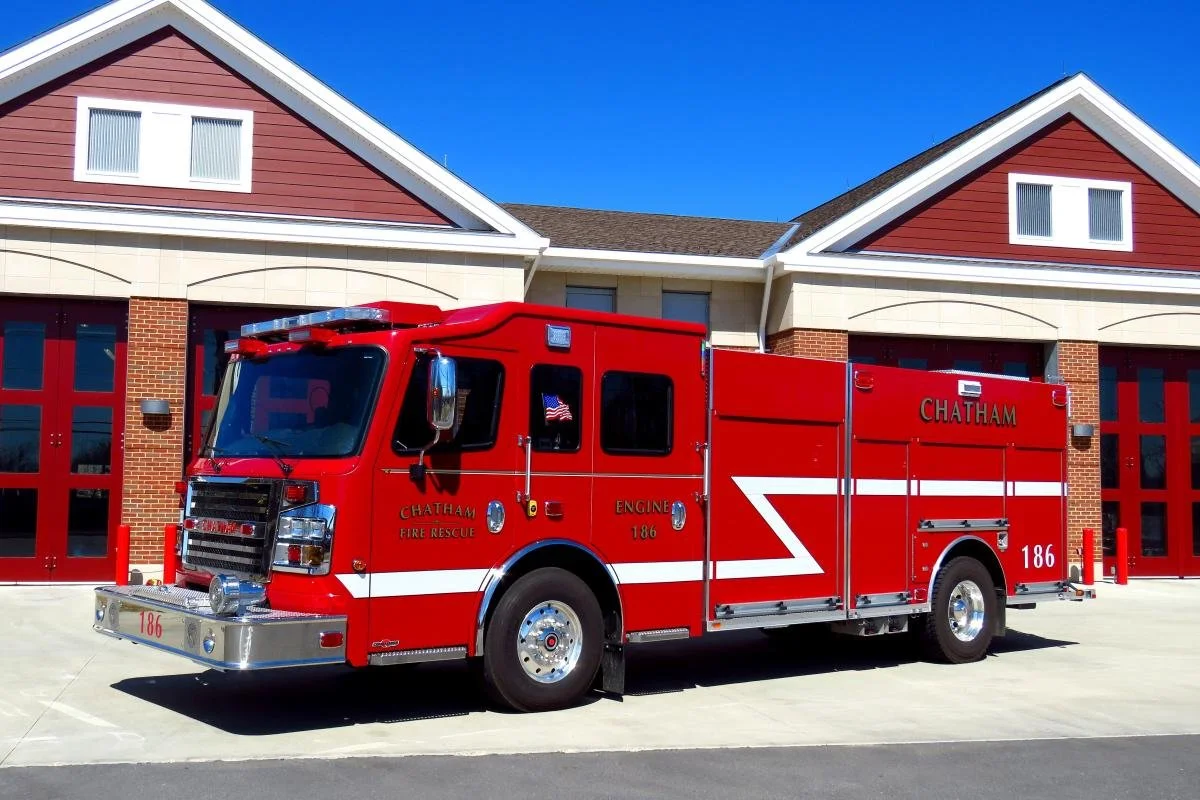 Red fire rescue truck parked outside a fire station.