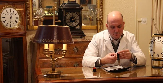 Desbiolles Artisans Horloger_Watchmaker inspecting watch.jpg