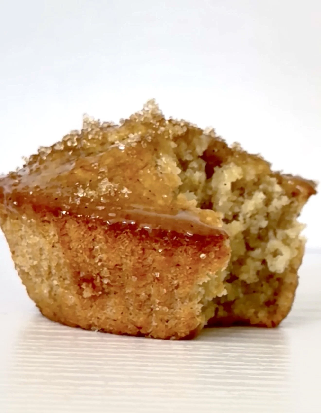 Close-up of a homemade vanilla oat  muffin on a white surface.