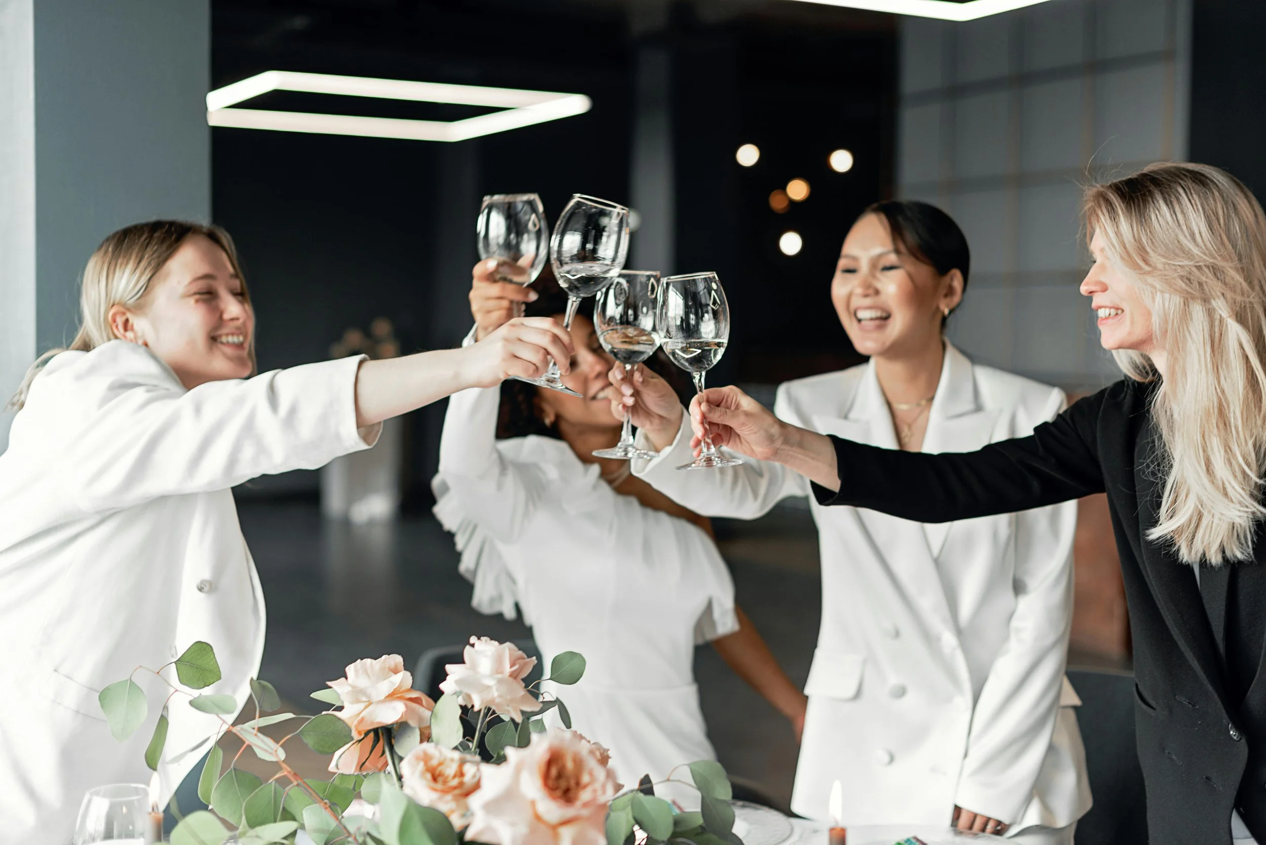 Group of women celebrating with wine glasses at a social gathering.