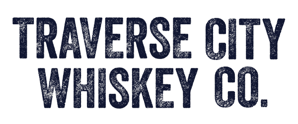 Text reading 'TRAVERSE CITY WHISKEY CO.' in bold, dark blue font on a black background.