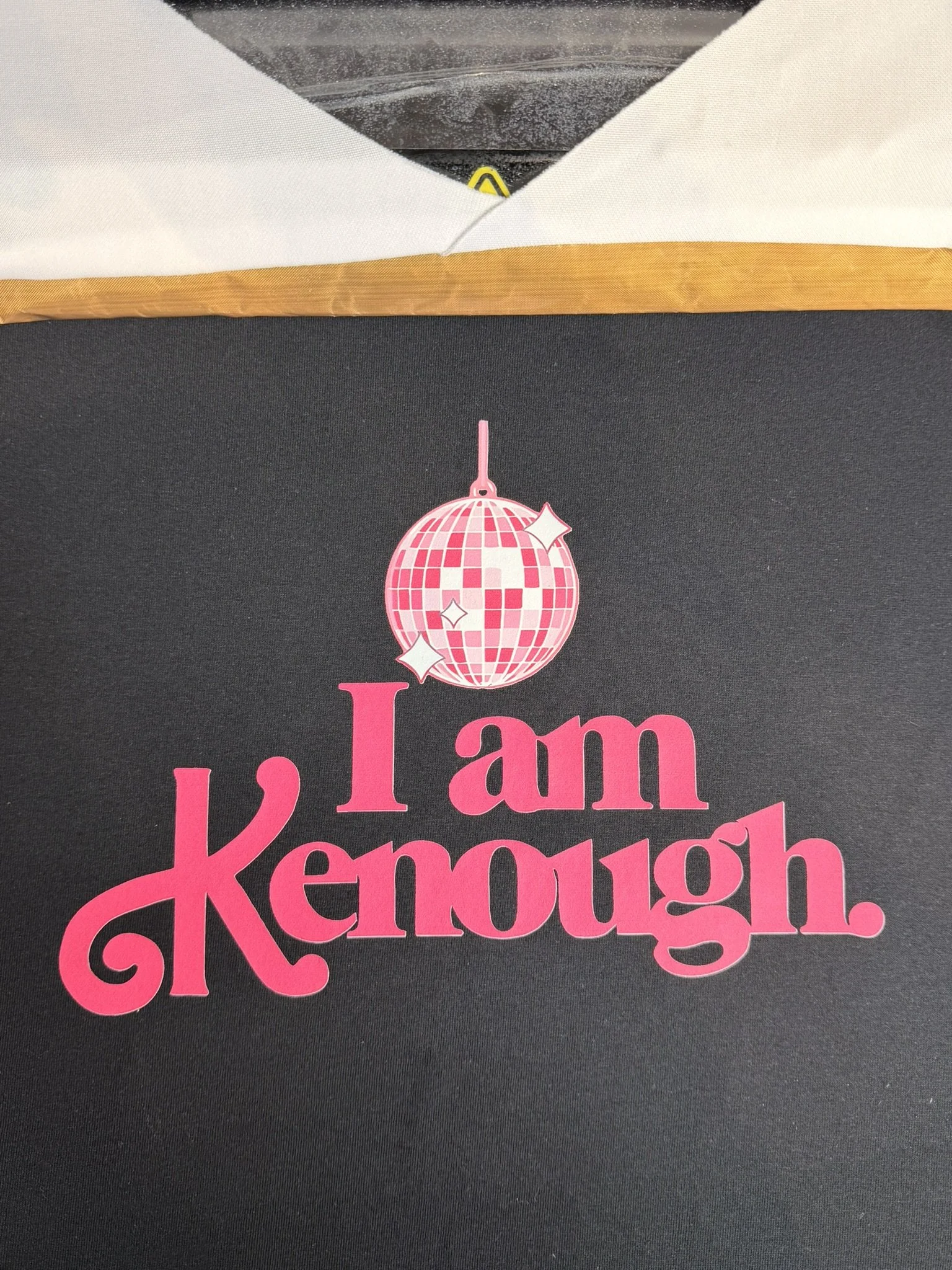 A black surface with a pink decal that reads "I am Kenough" and features a pink disco ball graphic.