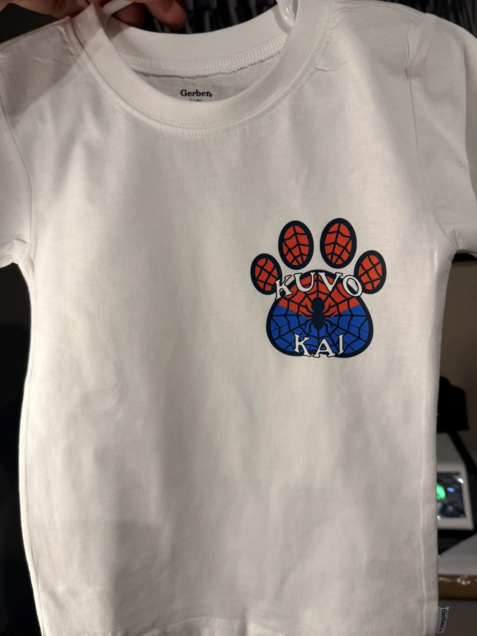 White T-shirt with a graphic of a paw print in red, black, and blue with the words 'KUTO KAI' inside the paw.