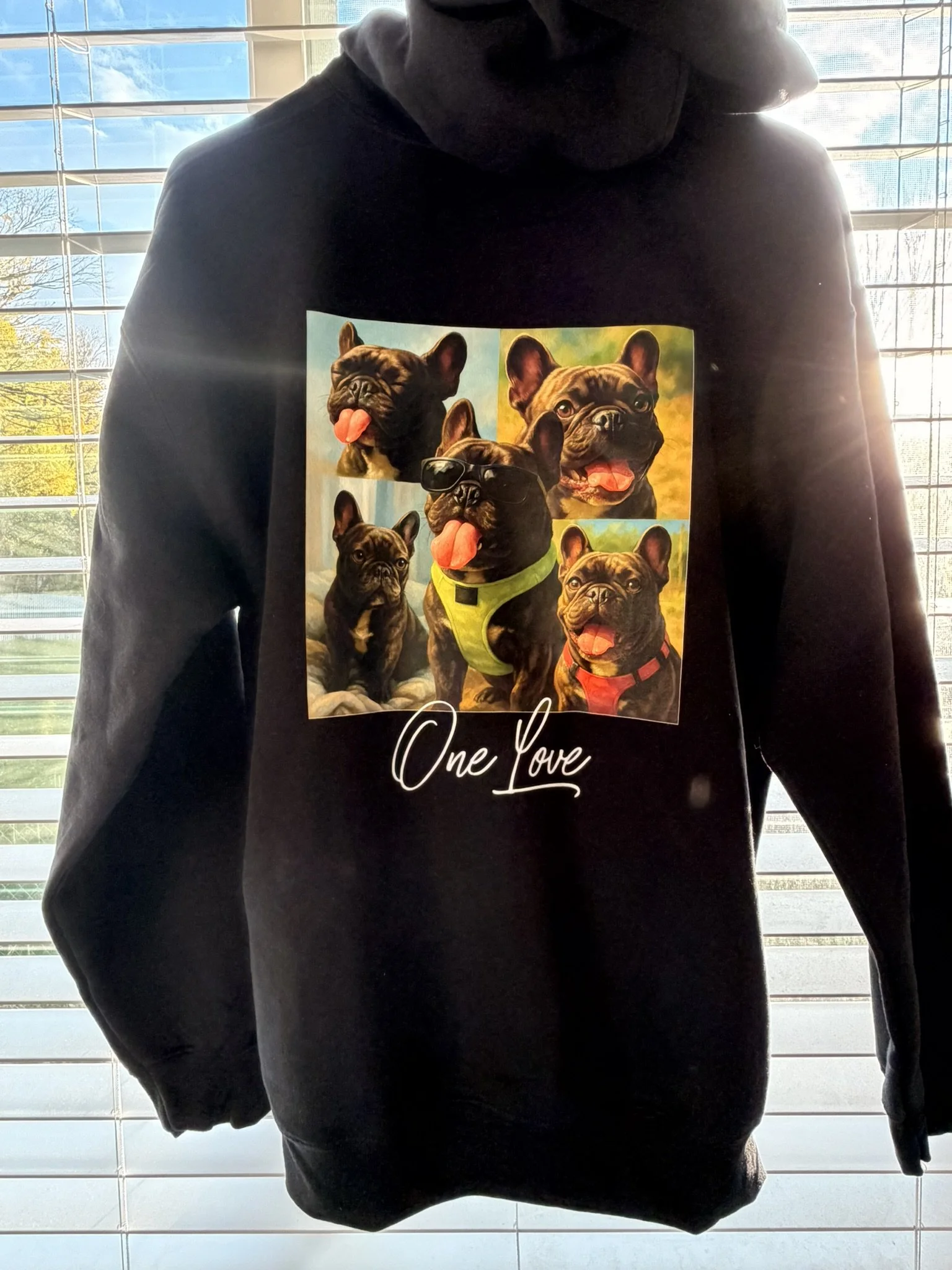 Black hoodie featuring a collage of five French Bulldogs displaying various expressions and poses, with the phrase 'One Love' written beneath the images.