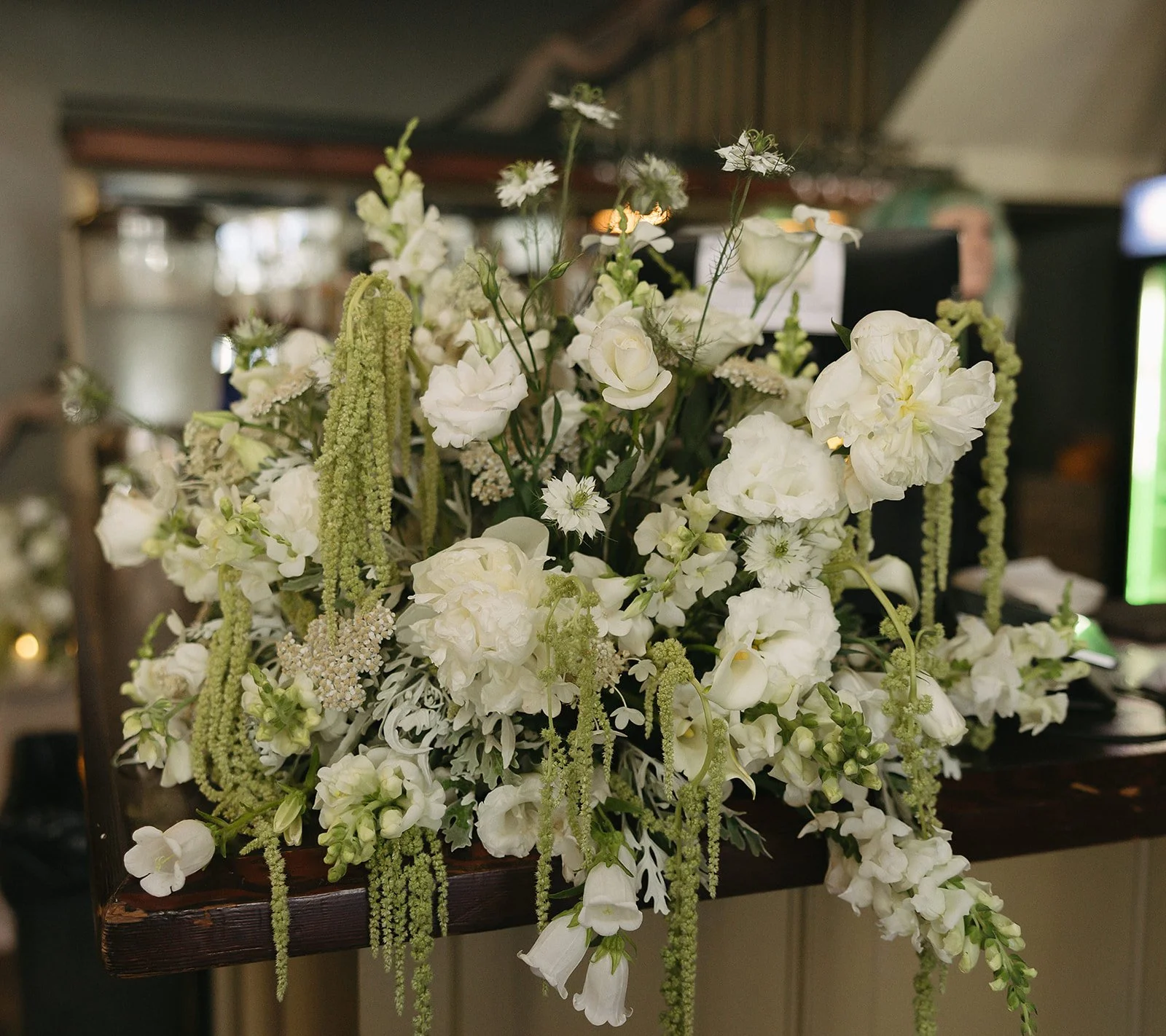 A  close up of a large white and green floral arrangement with white peonies, roses, lisianthus, and green cascading amaranth.

Photo: Mercedes Lou Photography
Venue: The Crystal Ballroom in Portland, OR
