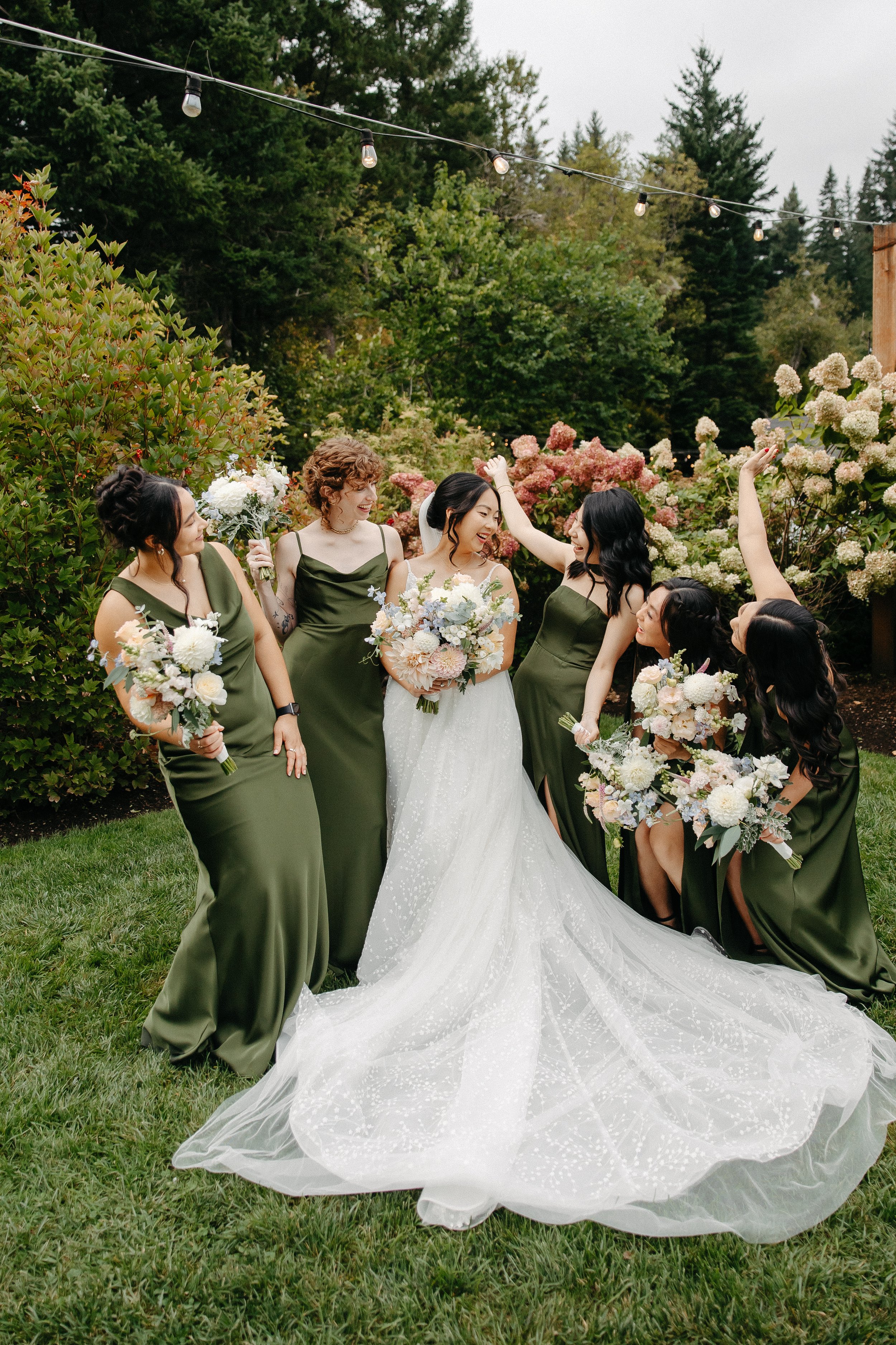 Group of women at a wedding, with the bride in a white gown and six bridesmaids in matching green dresses holding bouquets, in a garden setting with greenery and flowers.

Photo by Go Lovin Co Photography
Venue Cape Horn Estates