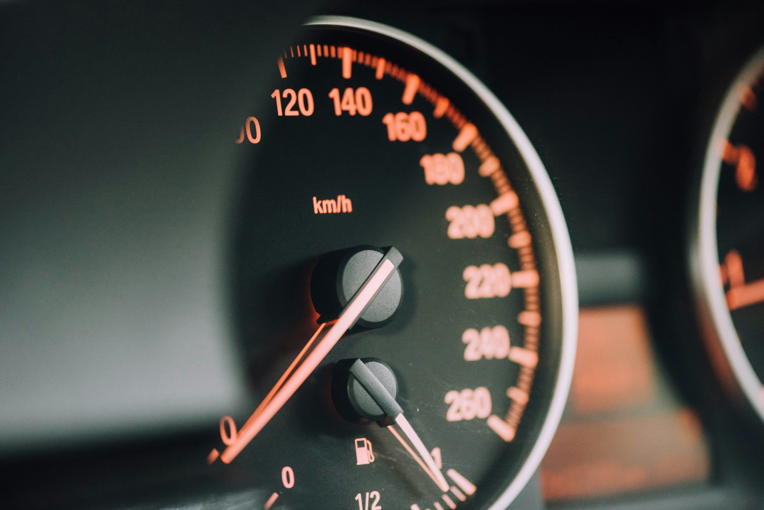 Close-up of a car's speedometer showing 140 km/h and a fuel gauge indicating close to empty.