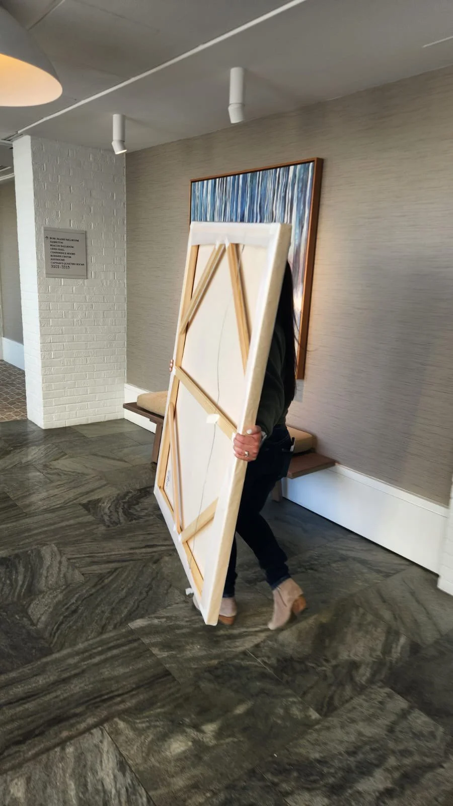 Samantha Paris Estes installing a large-scale painting for exhibition