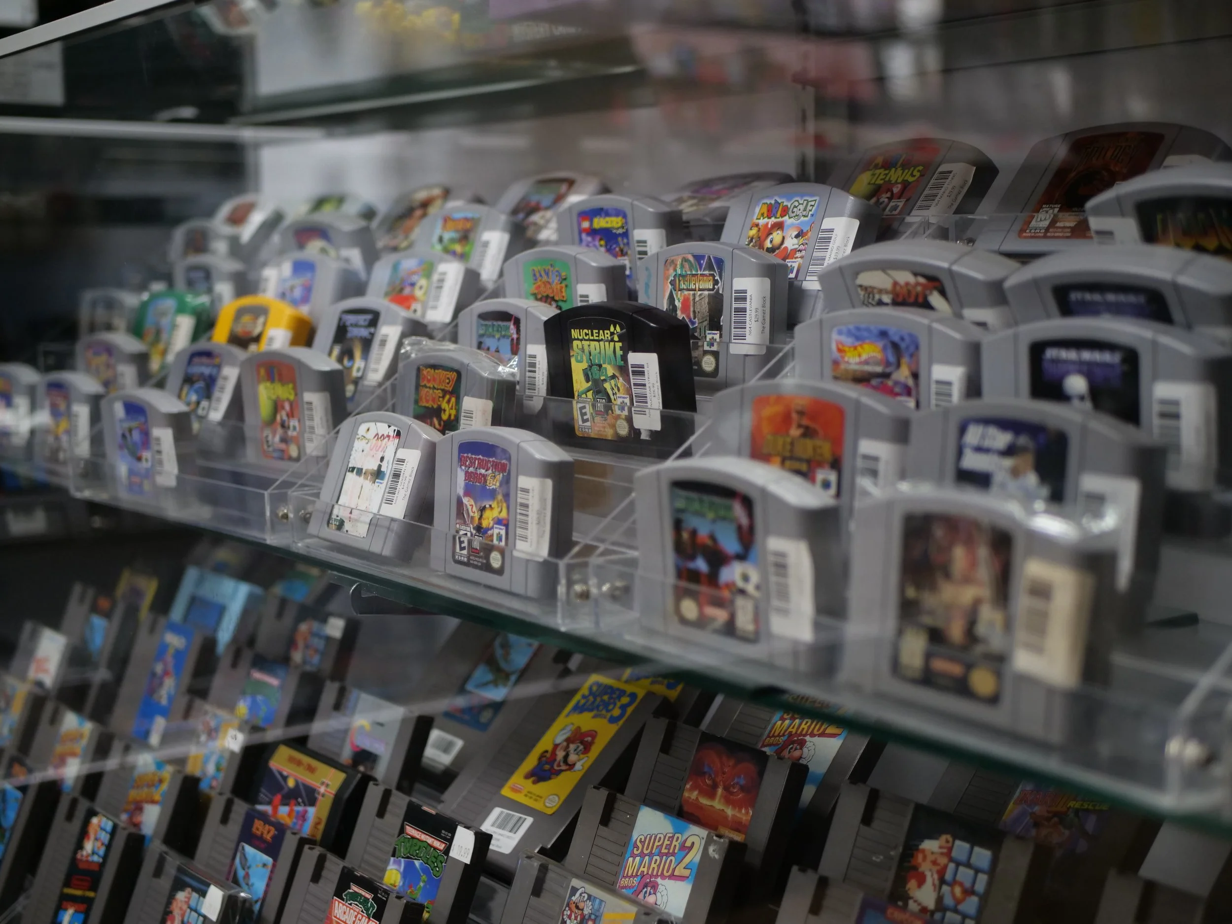 A display shelf with multiple Nintendo Game Boy Advance video game cartridges, arranged in rows and clear plastic compartments.