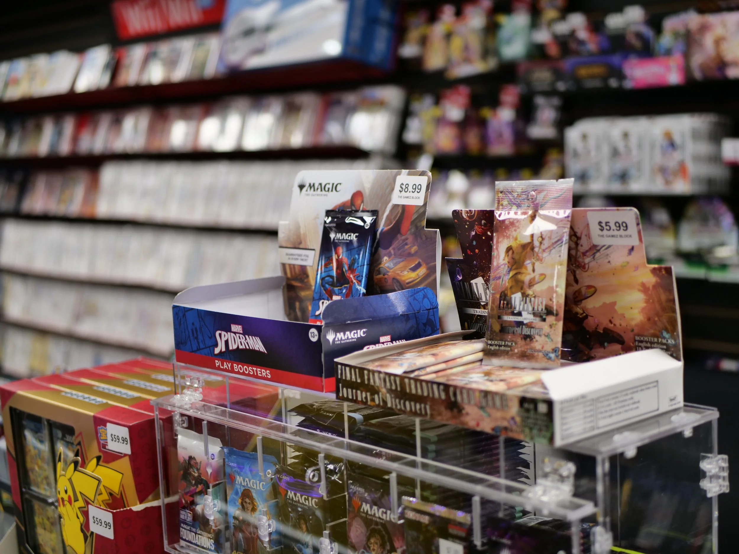 Display of Marvel Spider-Man and Final Fantasy trading card booster packs on a store shelf.